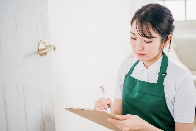 エプロンをした女性が何かを記入しているところ